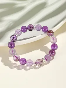 Gedetailleerde macro-opname van een lavendel amethist kralenarmband met zilveren bedels