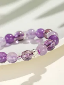 Macro-detail van een kralenarmband van lavendel amethist met een delicate zilveren bloembedel