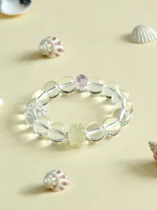 Nahaufnahme eines Citrin-Armbands mit geschnitzter Lotusperle und dekorativen Muscheln