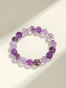 Gedetailleerde weergave van een lavendel amethist kralenarmband met zilveren strikjes