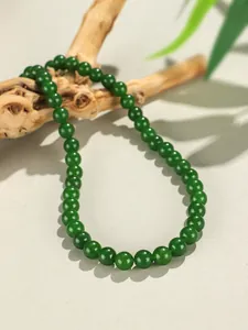 Dettaglio macro di perle tonde di calcedonio verde da 8mm su una collana di lusso.