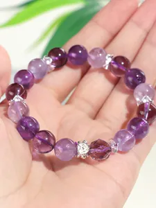 Detailopname van lavendel amethist kralenarmband met zilveren bloemkralen op hand