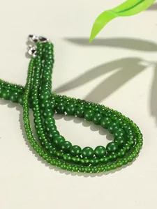 Macro dettagliata di perle tonde in calcedonio verde lucido dal colore vivace