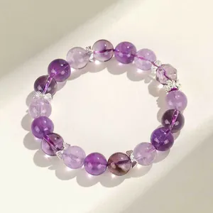 Elegante lavendel amethist kralenarmband met zilveren strikjes tussen de kralen.