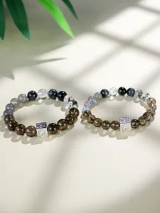 Nahaufnahme von Teequarz- und Mondstein-Perlenarmbändern mit strukturierten Metallteilen.