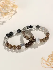 Nahaufnahme von Armbändern aus Rauchquarz und Mondstein mit silbernem quadratischem Anhänger