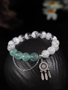 Dettaglio in primo piano del ciondolo acchiappasogni in argento 925 su bracciale di perle