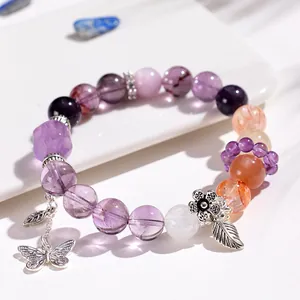 Vista detallada de pulsera de amatista de varias piedras con dijes de plata de mariposa