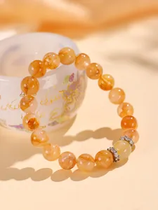 Primer plano de una pulsera de cuentas de cuarzo rutilado amarillo con cristales brillantes