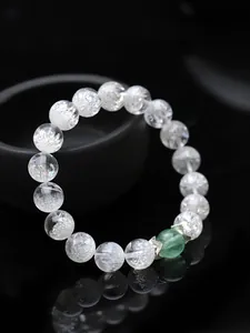 Dettaglio di un bracciale di cristallo con gemma verde e distanziatori in argento