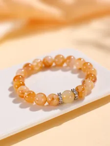 Primer plano detallado de una elegante pulsera de cuentas de citrino y cuarzo rutilo