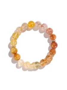 Vista de cerca de pulsera de cuarzo rutilado dorado y cristal amarillo con grabado Pixiu.