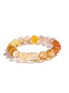 Detalle de pulsera de cuentas de citrino y cuarzo rutilado dorado con Pixiu tallado