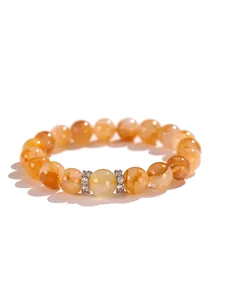 Primer plano detallado de una pulsera de cuarzo amarillo con brillantes espaciadores de plata