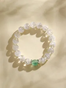 Dettaglio ravvicinato del braccialetto in cristallo trasparente con perla verde.