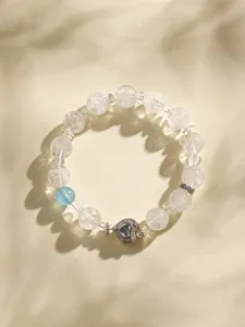 Primo piano di perle di cristallo scintillanti e ciondolo a cuore in argento sotto le ombre