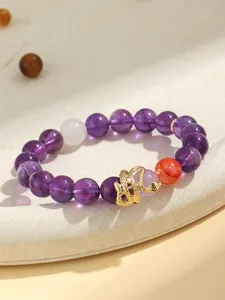 Detail of purple amethyst beaded bracelet with golden snake charm for women