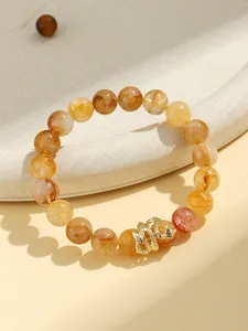 Detailed close-up view of yellow quartz beaded bracelet with a golden snake charm