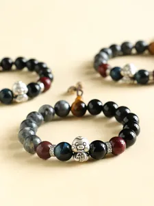 Detailed view of S999 silver snake charm on black agate and blue tiger eye bracelet.