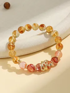 Detailed shot of Year of the Snake beaded bracelet with yellow phantom crystals and gold snake charm