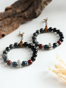 Macro detail of 999 silver lucky charm and natural stone beads on a bracelet