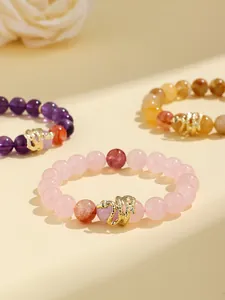 Detail shot of Year of the Snake rose quartz beaded bracelet with gold snake charm