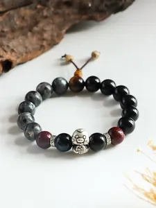 Close-up of beaded bracelet featuring natural stones and a silver zodiac snake charm