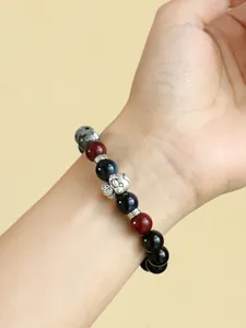Macro view of 999 silver fortune snake bracelet with black onyx and blue tiger eye beads