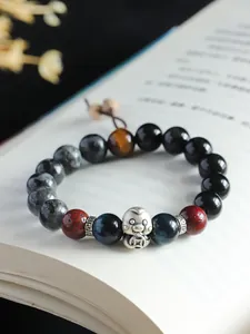 Close-up detail of a multi-stone beaded bracelet featuring a 999 silver lucky snake charm