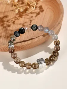 Detailansicht des natürlichen Rauchquarz- und Mondstein-Perlenarmbands mit Silberanhänger.
