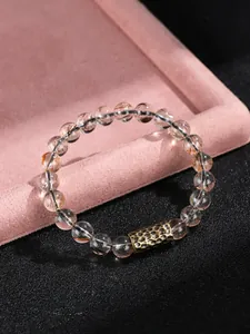 Detalle de pulsera de cristal super seven de oro negro con cuenta de metal martillado