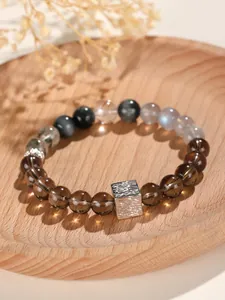 Detailansicht des Perlenarmbands mit Rauchquarz, Mondstein und gehämmerter Silberwürfel.