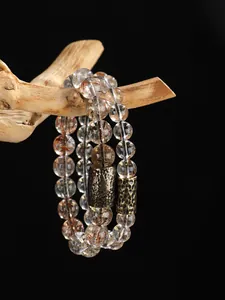 Vista detallada de la pulsera de cristal Super Seven con un tubo de metal bronceado