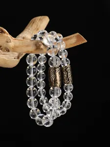 Detalle macro de pulsera de cuentas de cristal transparente con espaciadores dorados
