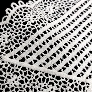 Macro detail of white water-soluble embroidered lace collar with hollow pattern