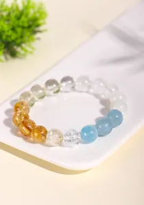 Detalle de una pulsera de cuentas de cristal natural multicolor en una bandeja.