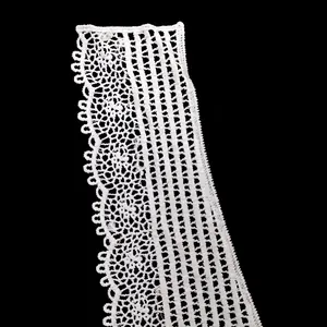 Close-up of white water-soluble lace trim with intricate hollow embroidery pattern