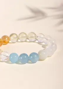 Primer plano de una pulsera de cristal natural con cuentas de aguamarina y citrino.