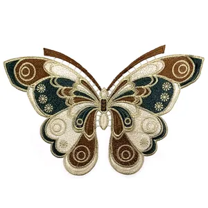 Detail of an intricate butterfly embroidery patch with gold thread and hollowed lace design
