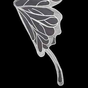 Detailed macro view of white butterfly wing lace embroidery patch showing mesh texture