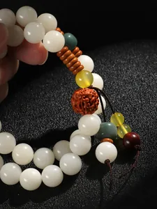 Detailaufnahme eines weißen Bodhi-Armbands mit Rudraksha und bunten Akzentperlen