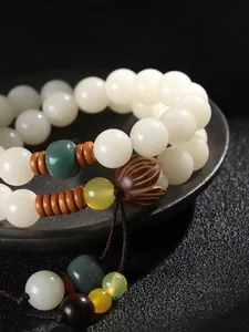 Detaillierte Makroansicht eines weißen Bodhi-Samen-Armbands mit geschnitzter Lotosperle