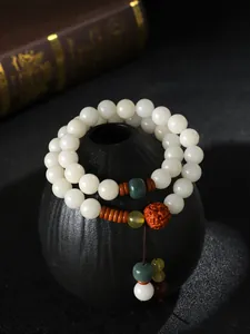 Nahaufnahme eines weißen Bodhi-Samen-Doppelschleifen-Armbands mit ethnischem Charme.