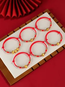 Vue détaillée de six bracelets tressés rouges de l'année du serpent avec breloques dorées