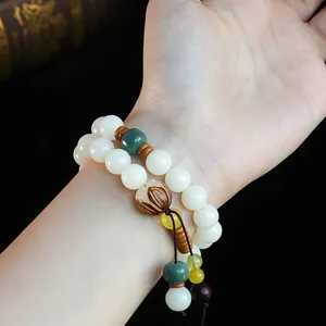 Elegantes ethnisches zweilagiges weißes Bodhi-Perlenarmband an einem zarten Handgelenk