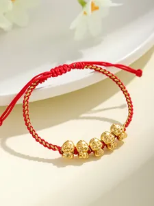 Dettaglio del bracciale a corda rossa fatto a mano con cinque ciondoli a forma di serpente d'oro