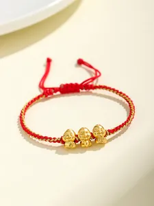 Vista dettagliata di un bracciale in corda rossa intrecciata con tre ciondoli a serpente.