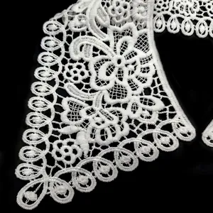 Detailed macro view of white water-soluble lace collar with floral embroidery