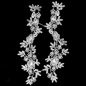 Nahaufnahme von weißen symmetrischen floralen Spitzenapplikationen mit Rosenmustern.