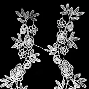 Nahaufnahme einer feinen weißen floralen Stickspitze mit eleganten Rosenmotiven